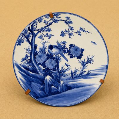 une assiette bleue et blanche ornée d'un oiseau et de fleurs