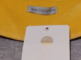 the label on a yellow shirt is attached to the collar of a yellow shirt