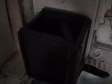 a black trash can in the corner of a kitchen