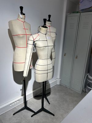 two mannequins sitting on a stand in a room