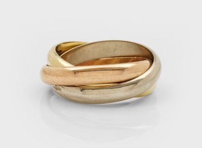 une image représentant une bague en or et en argent posée sur une surface blanche
