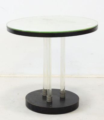 une table ronde en verre avec un piètement noir et un plateau vert
