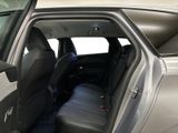 a silver car with its door open and the seats folded down
