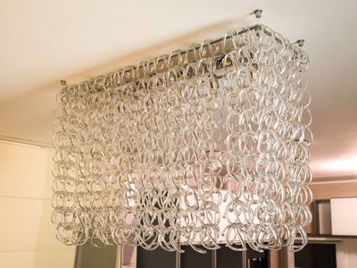 a glass chandelier hanging from the ceiling in a kitchen