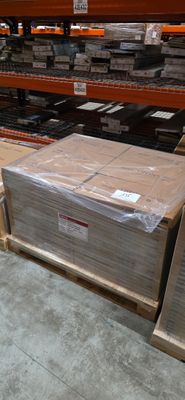 Les cartons sont empilés sur des palettes dans un entrepôt dont les rayonnages sont remplis de cartons