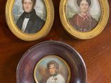 two miniature portraits of a man and a woman on a table