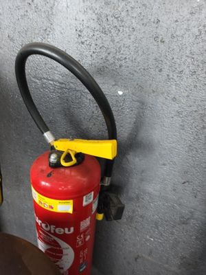 un extincteur à côté des toilettes dans une salle de bains
