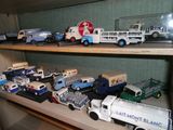 de nombreux camions miniatures posés sur une étagère dans une pièce