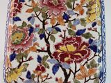 un gros plan d'une assiette décorée de fleurs et de feuilles