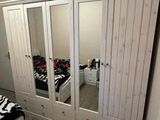 a bedroom with a closet and a bed with a zebra print blanket on it
