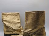 a close up of a pair of gold boots on a white background