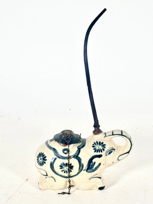 un vase bleu et blanc d'où sort un long bâton