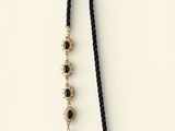 a black and gold beaded necklace with a tassel