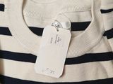 a close up of a striped sweater with a tag on it