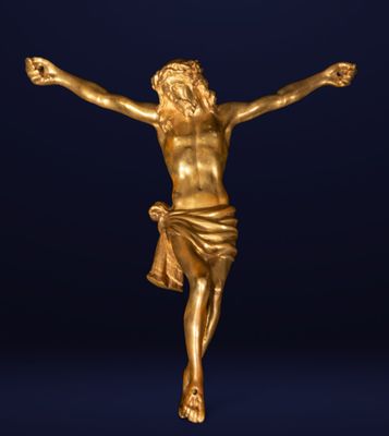 une statue en or représentant Jésus sur la croix, sur fond bleu