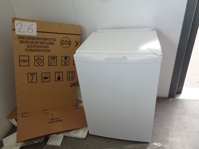 a white refrigerator next to a cardboard box on the floor