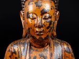 an image of a statue of a buddha sitting on a black surface