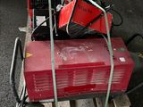a red machine sitting on top of a pallet in a warehouse