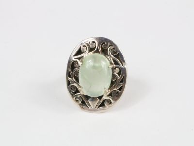 Gros plan sur une bague contenant une pierre verte