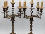 pair of antique brass candelabs with candles on each of them