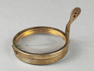 une loupe avec un manche en bois posée sur une table