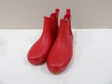 une paire de bottes de pluie rouges posées sur une surface blanche