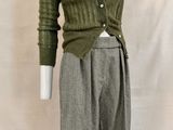 a mannequin wearing a green sweater and grey pants