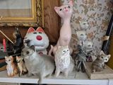 de nombreux chats assis sur une étagère, à côté d'un miroir