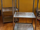 une table en métal avec deux étagères, dans une pièce