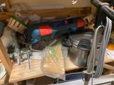 a cluttered garage with tools and supplies on the shelves