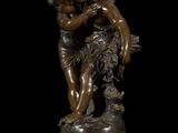 an antique bronze statue of a woman holding a child