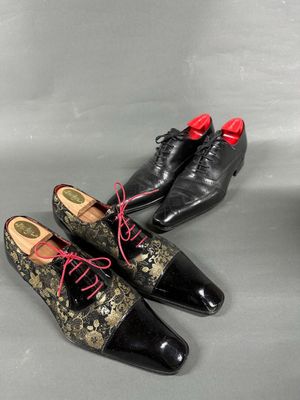 two pairs of black and gold shoes with red laces