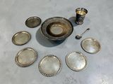 Plusieurs plats et cuillères en argent sont disposés sur une table