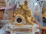 une horloge en or sous un dôme de verre sur une table