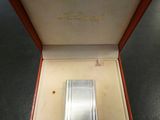 an image of a silver lighter in a red box on a table