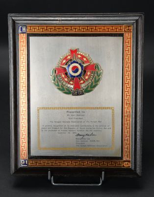 une photo montrant une médaille et un certificat encadrés