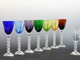 several different colored wine glasses are lined up in a row