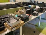 many computers on a table in a room