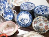 many plates and cups on a table with a pair of scissors