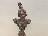 une statue en bronze représentant une femme avec un oiseau sur la tête