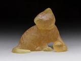 figurine en jade jaune représentant un chat, posée sur un fond blanc