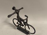 figurine en métal représentant un homme à vélo sur une luge