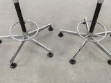 pair of black and chrome stools on casteors on concrete floor