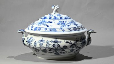 une soupière bleue et blanche surmontée d'un oiseau