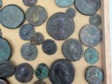 a lot of coins in a wooden box on a table
