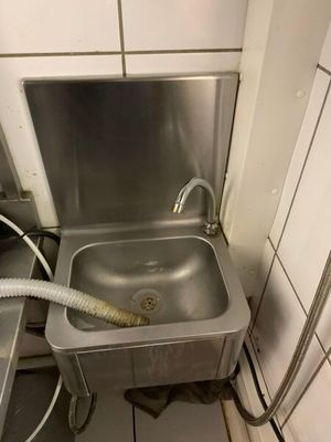 un lavabo muni d'un tuyau d'arrosage dans une salle de bains