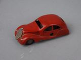 a red toy car that is on a white surface