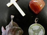 three different types of pendants and a cross on a table
