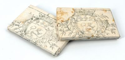 deux vieux livres posés l'un sur l'autre sur une surface blanche