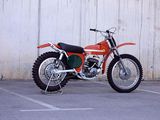a red dirt bike parked in a parking lot